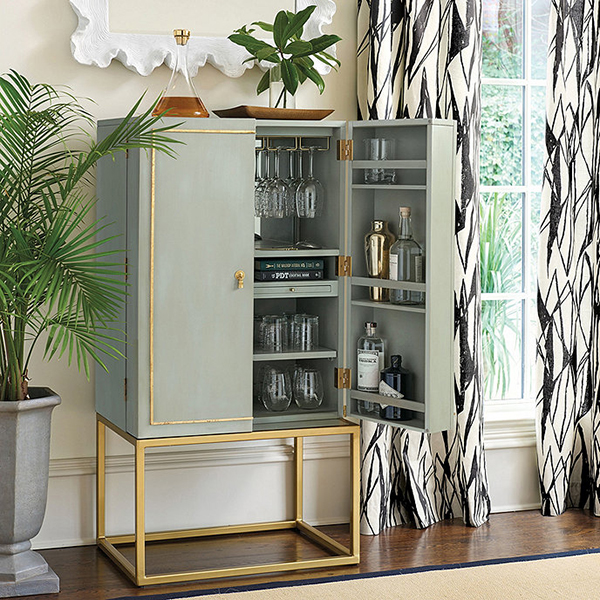 A half-open Campaign-style bar cabinet that's filled with glassware