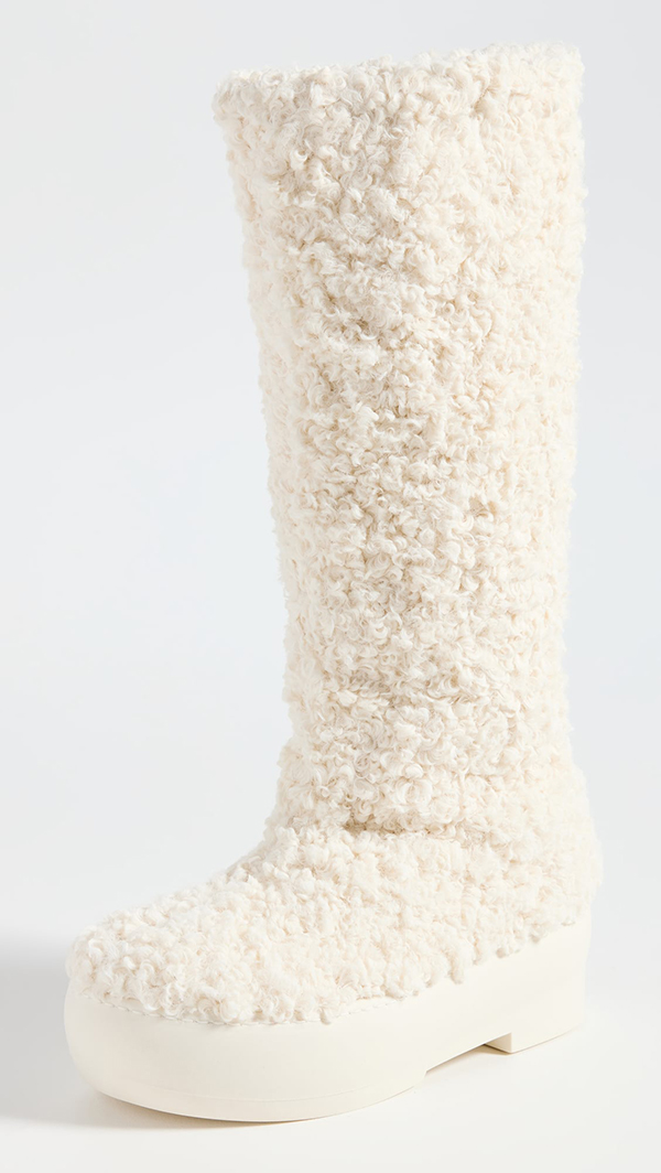 A chunky knee-high boot lined with white bouclé fabric