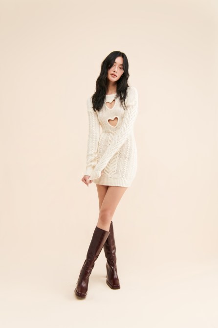 Nuuly model wearing white dress and tall leather boots.