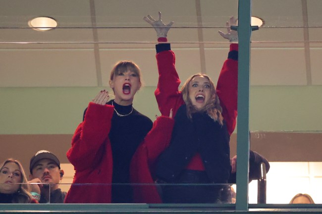 Taylor Swift, in a black turtleneck and red cardigan, and Brittany Mahomes, in a black and red bomber jacket, cheer on the Chiefs in a game against the Packers