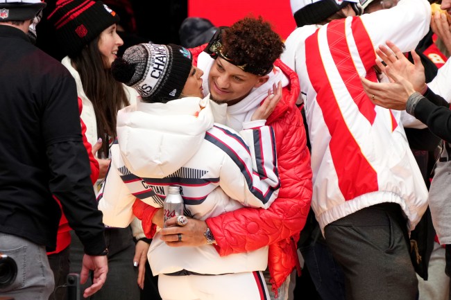 Patrick Mahomes #15 of the Kansas City Chiefs and wife Brittany Mahomes celebrate on stage during the Kansas City Chiefs Super Bowl LVII victory parade on February 15, 2023 in Kansas City, Missou