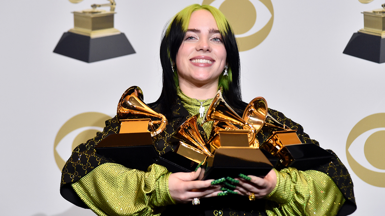 Billie Eilish holding Grammys