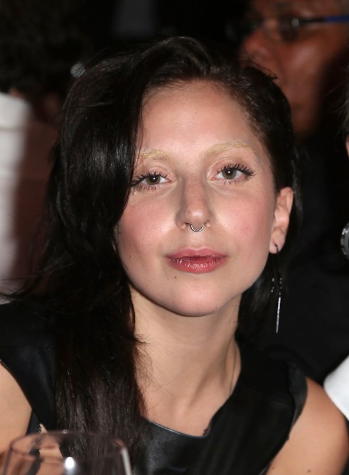 Lady Gaga with black hair and bleached brows.
