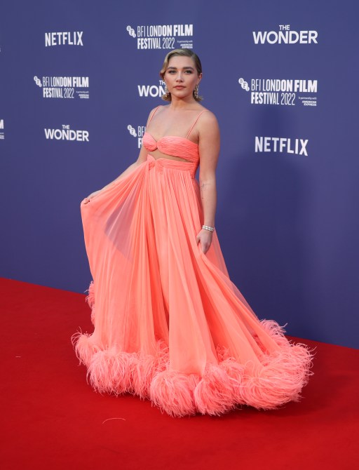 Florence Pugh in a salmon evening gown with feather detailing at the UK premiere of "The Wonder" red carpet