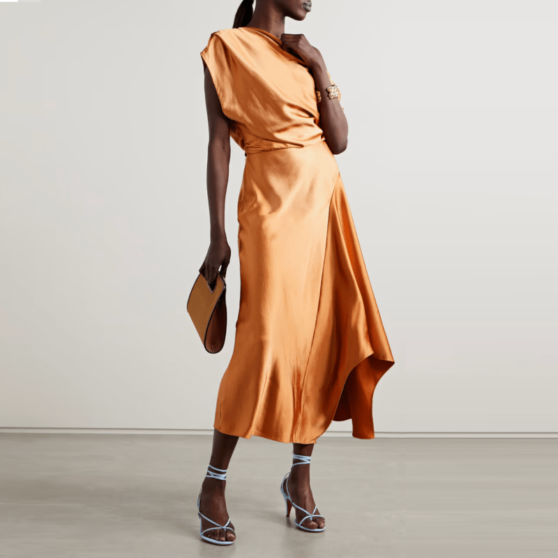 A model wearing an orange silky drapey midi dress