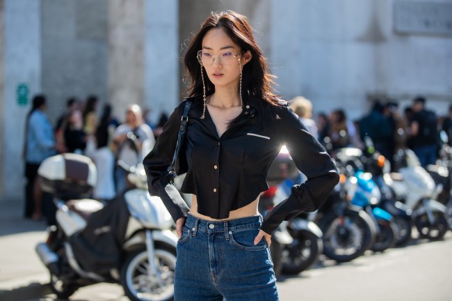 Model in wire-frame glasses, a black top, and jeans at Paris Fashion Week