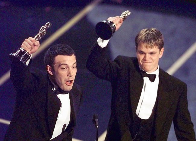 Ben Affleck (L) and Matt Damon hold up their Oscars after winning in the Original Screenplay  Category during the 70th Academy Awards at the Shrine Auditorium 23 March. The two won for their Original Screenplay "Good Will Hunting."