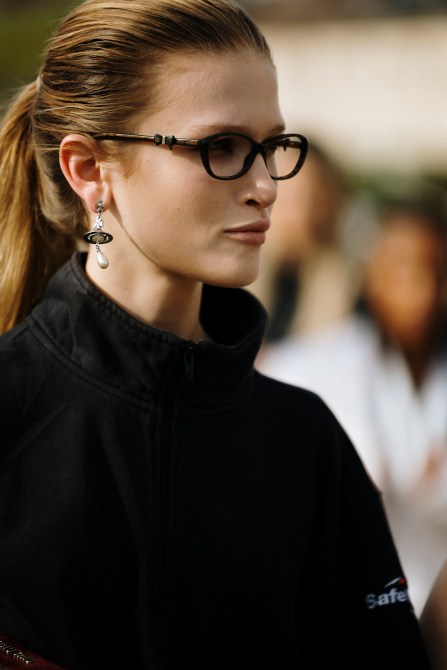 A fashion week guest wearing Vivienne Westwood pearl drop earrings.