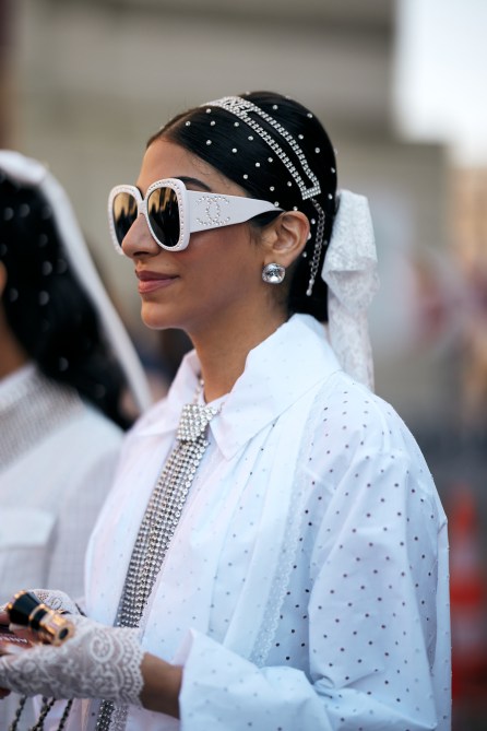 A fashion week guest wearing oversized gem earrings.