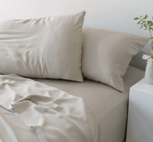 A grey bed sheet set including two pillows covered in pillow cases