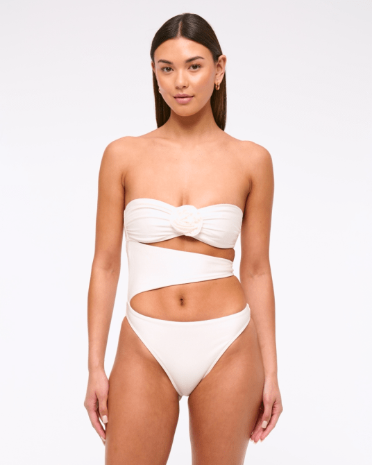 A model wearing the Abercrombie & Fitch Rosette Cutout One-Piece Swimsuit in white