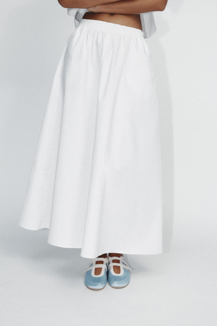 A model wearing the Zara Satin Effect Topstitched Ballerina Flats in light blue and white
