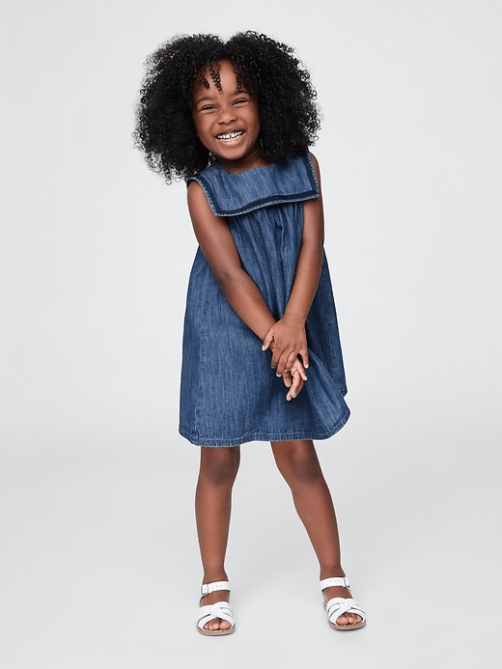 A child model wearing the Baby & Toddler Denim Sailor Dress in indigo