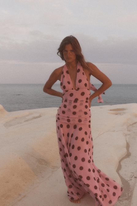 A model wearing the Zara Polka Dot Maxi Dress in a light pink and dark brown colorway