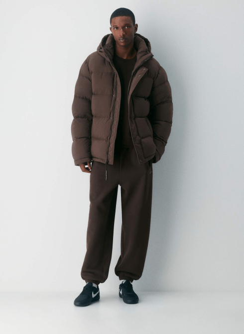 A male model wearing the Aritzia The Super Puff™ Men's - cliMATTE™ in Rich Mocha Brown